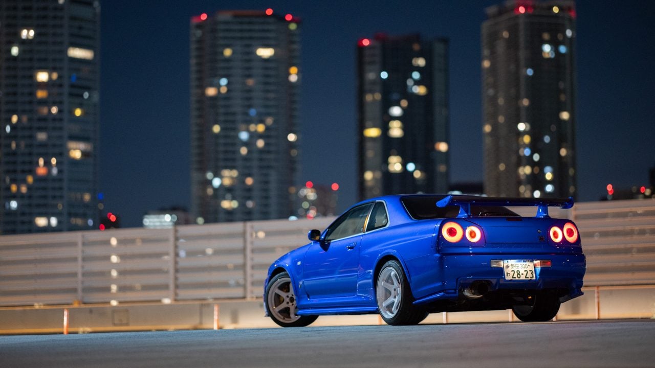 Larry Chen's restored R34 GT-R under city lights.