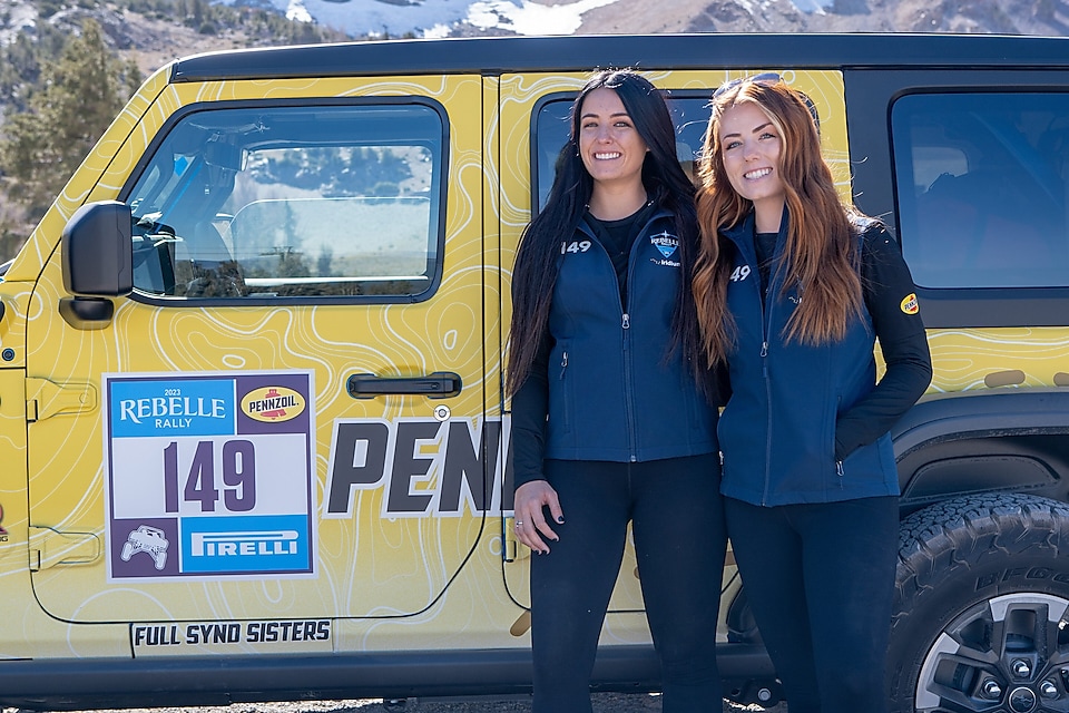 women standing in front of Jeep