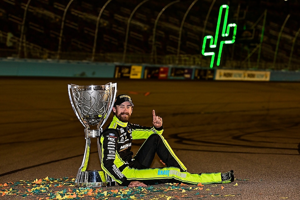 A person sitting on the ground with a trophy