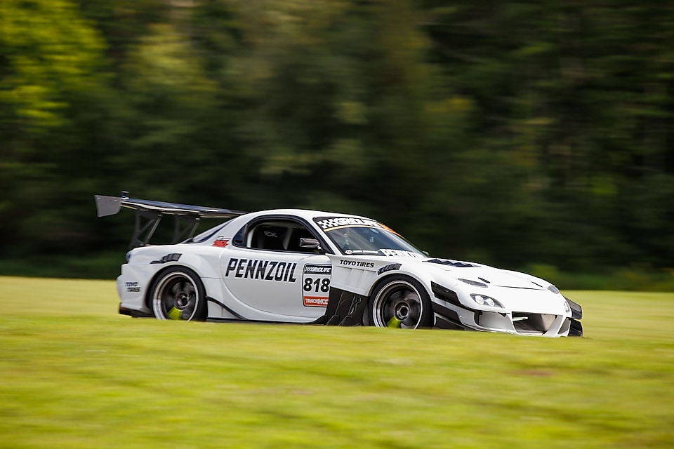 A white race car on a grass field