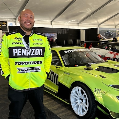 A person standing in front of a green car