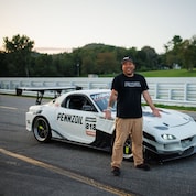 A person standing next to a white race car
