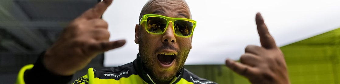 A person wearing sunglasses and green jacket