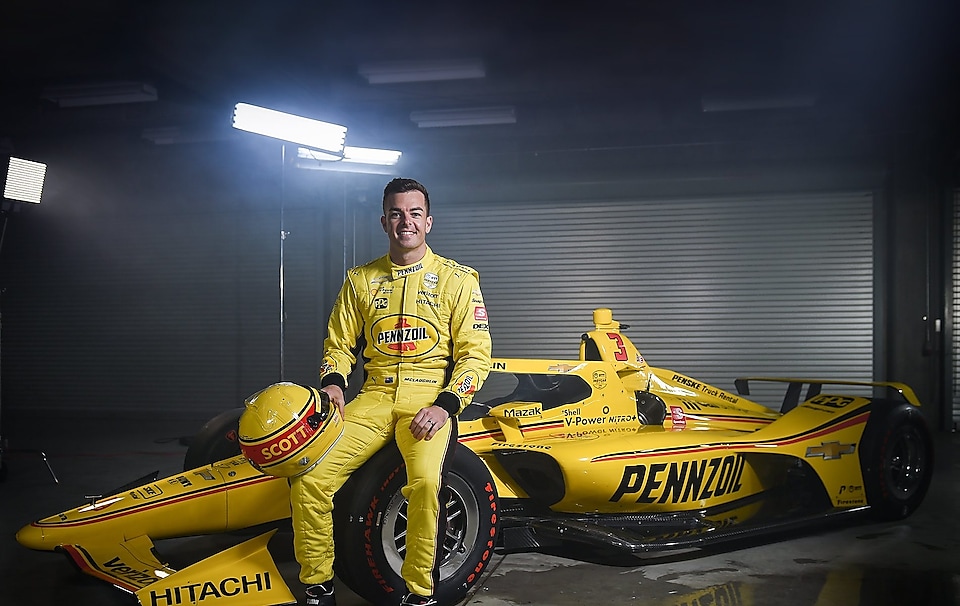 Scott McLaughlin posing in front of his yellow Pennzoil race car