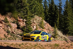 A yellow race car on a dirt road