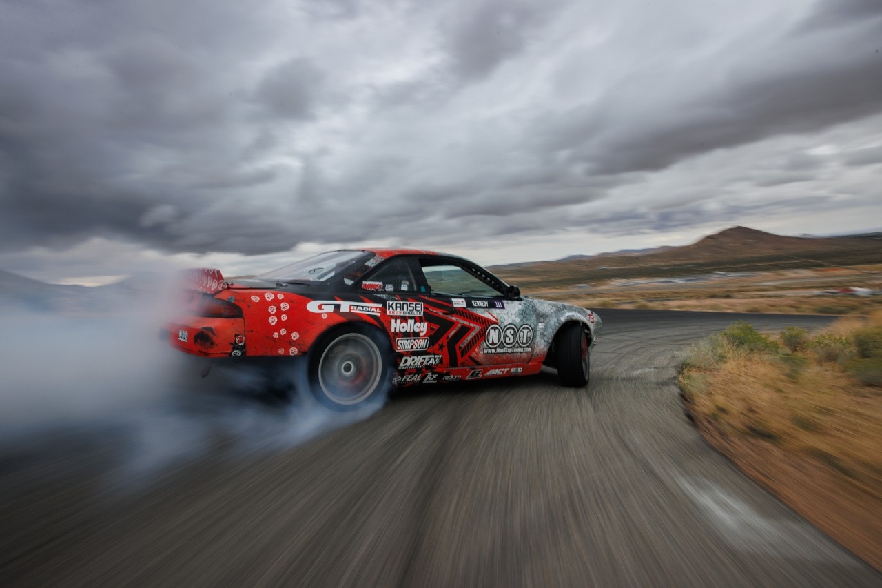 A car on a road with smoke coming out of the front