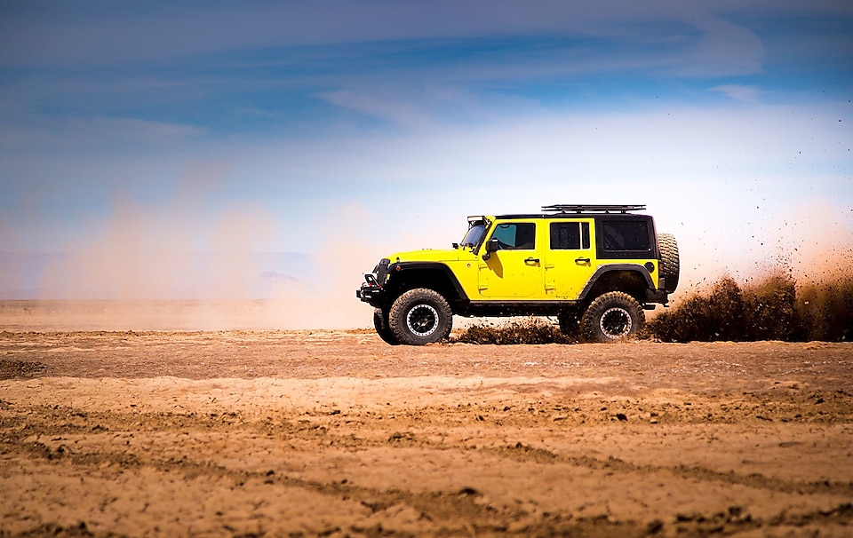 yellow jeep automobile in a desert scene