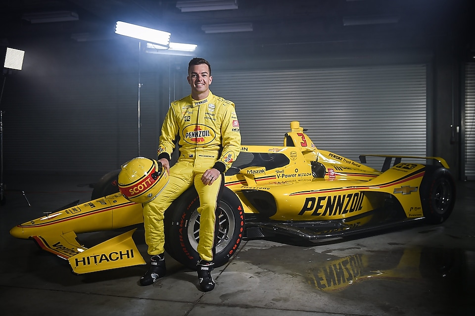 Scott Mc sitting on racing car and laughting