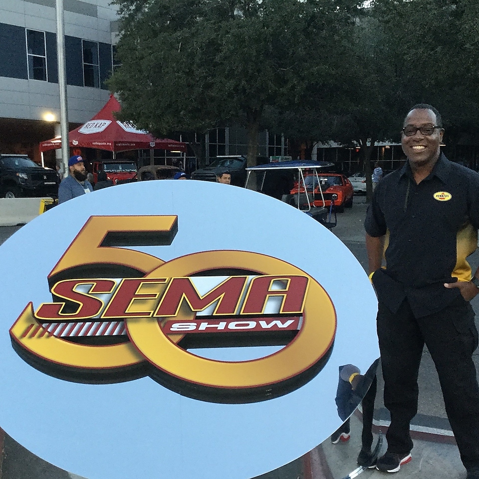 Michael beside large SEMA sign