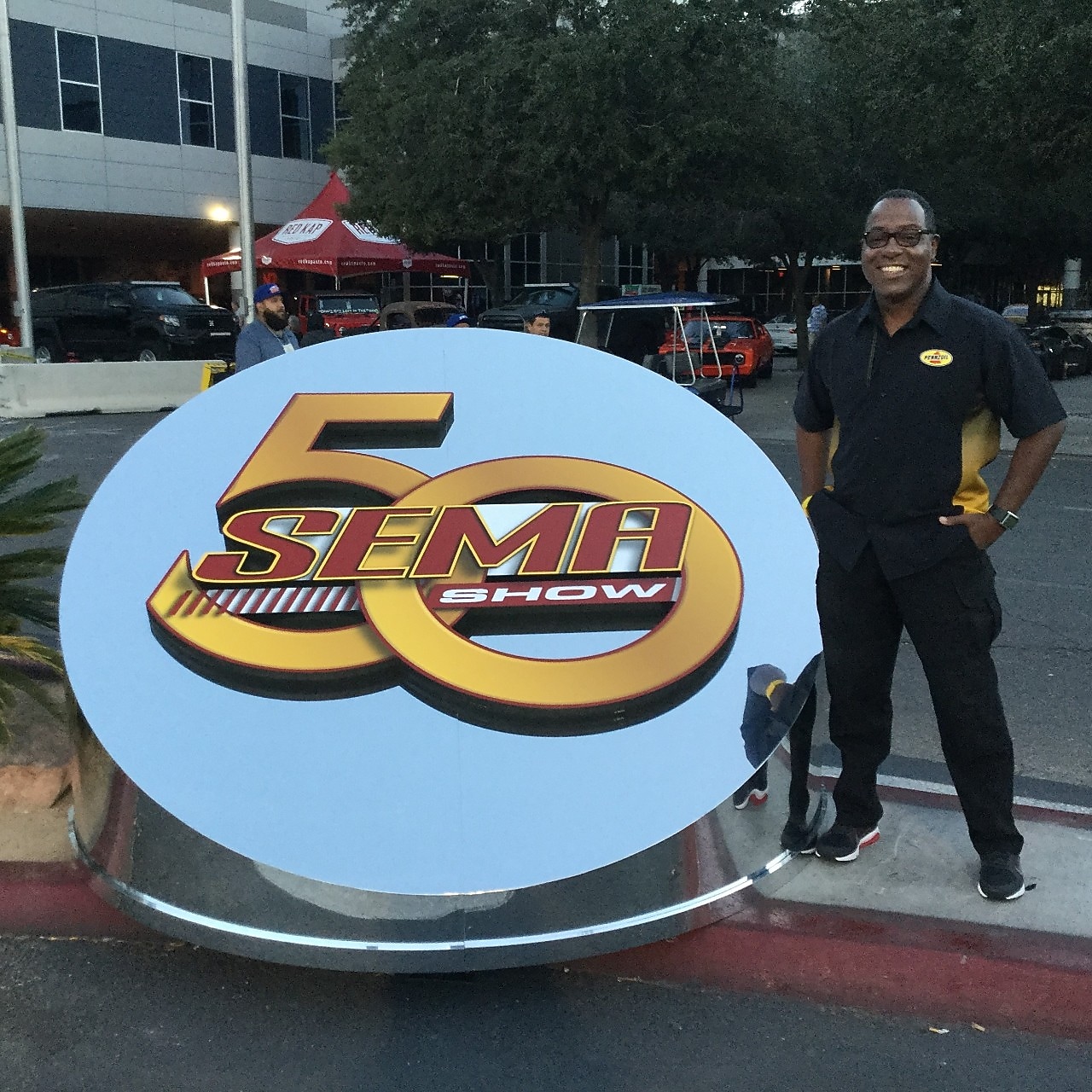 Michael beside large SEMA sign