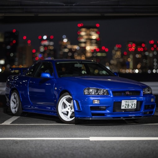 Larry Chen's restored R34 GT-R under city lights.