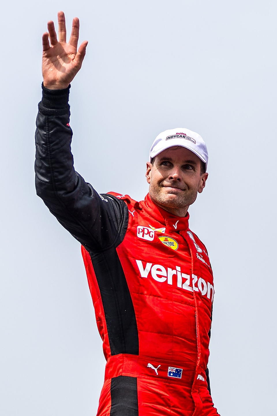 Man in red racesuit waving