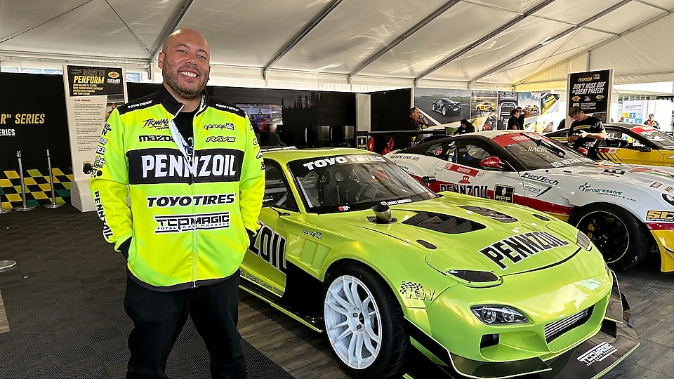 A person standing in front of a green car