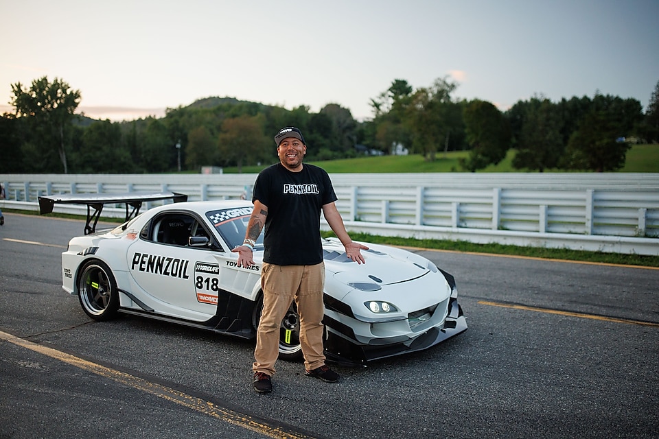 A person standing next to a white race car
