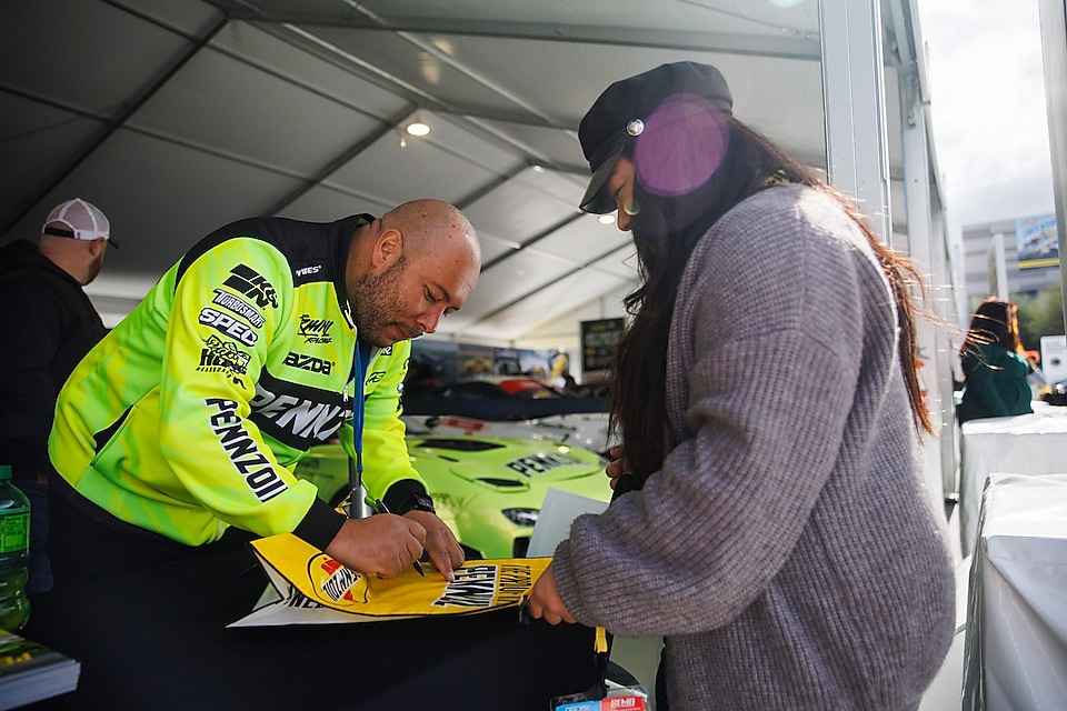 A person signing a book with a person