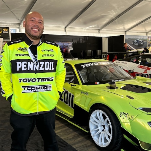 A person standing in front of a green car