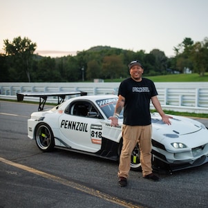 A person standing next to a white race car