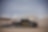A black truck driving on a dirt road