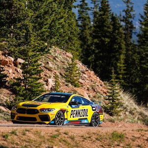 A yellow race car on a dirt road