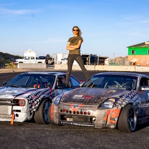 A person standing on top of two cars 