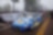A blue race car on a road with people watching