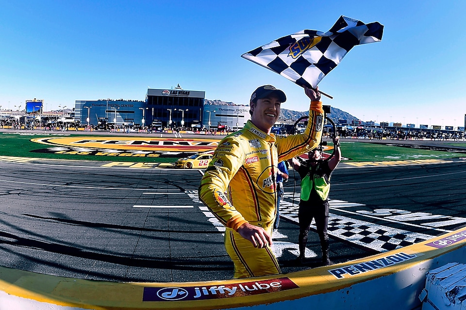 Joey Logano waves the checkered flag