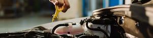 Automotive Service Technician checking an engine’s motor oil