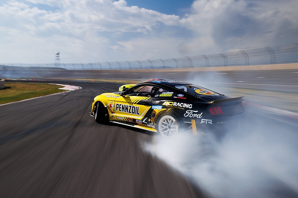 Pennzoil à l’œuvre, laissant une traînée de fumée sur la piste, photo prise par Larry Chen.