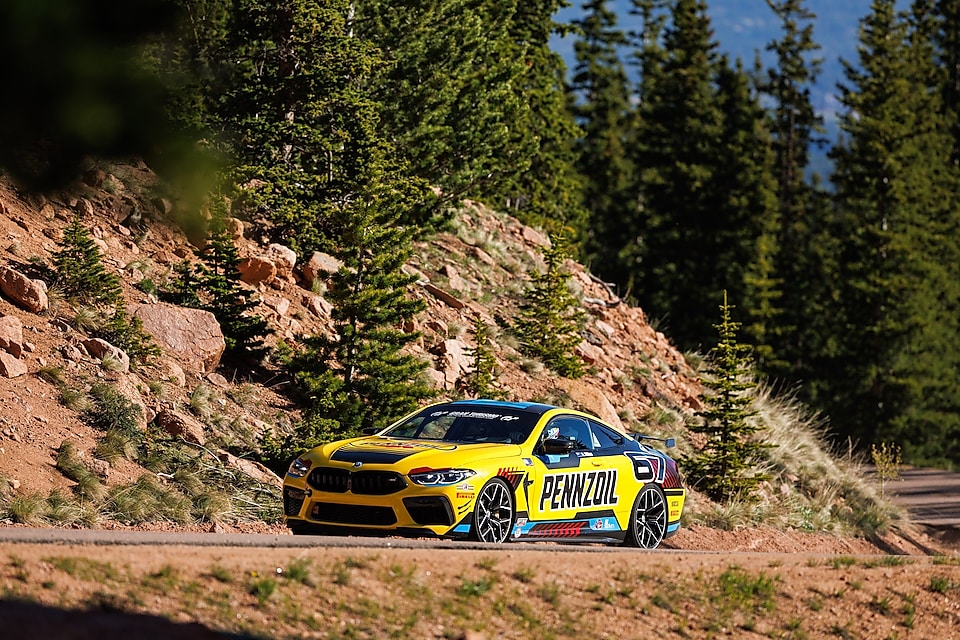 Une voiture de course jaune sur un chemin de terre